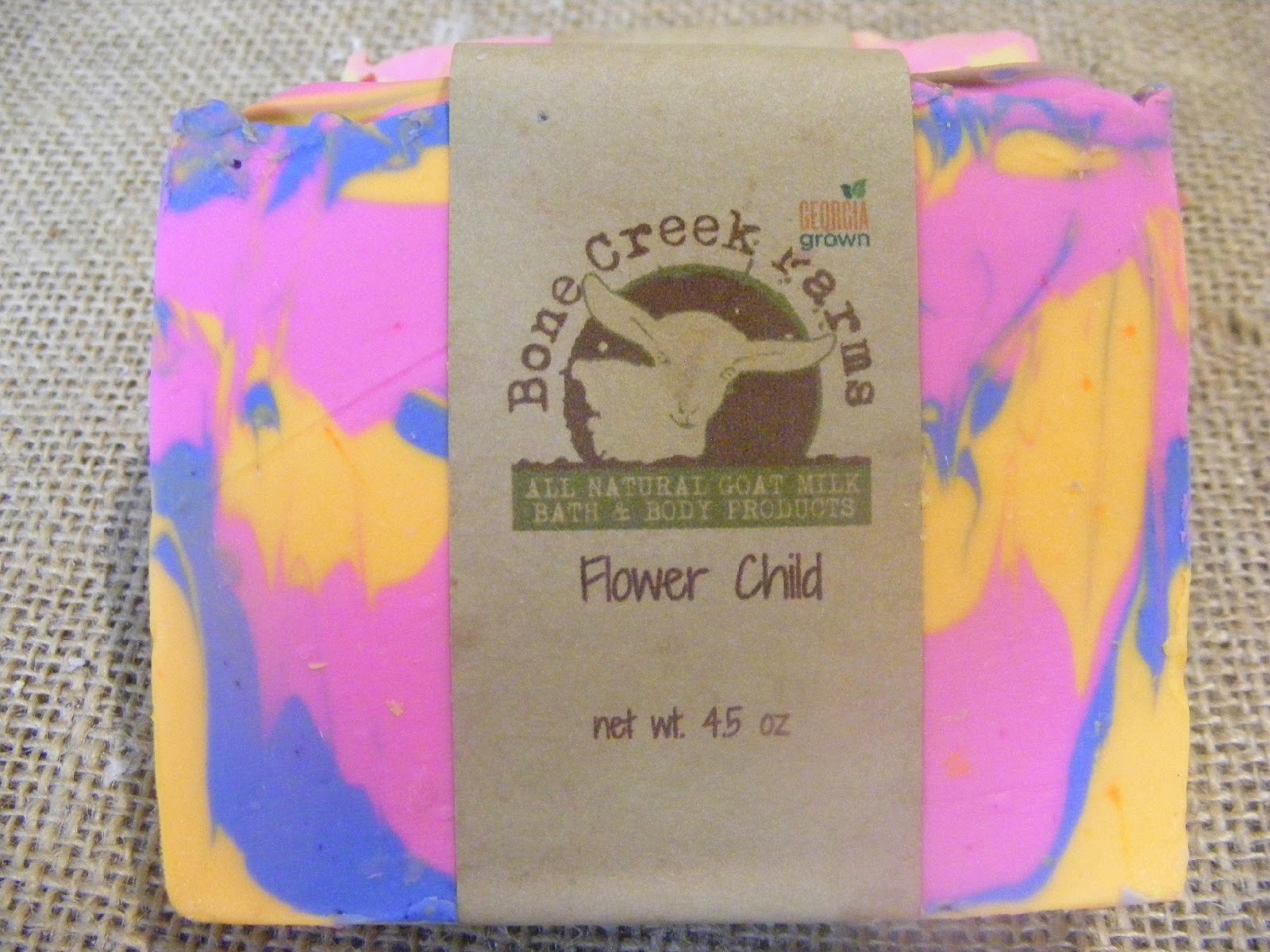 flowerchild Colorful handmade goat milk soap from Bone Creek Farms, labeled "Flower Child," featuring vibrant pink, blue, and yellow swirls. Weighs 4.5 oz and promotes natural skincare.